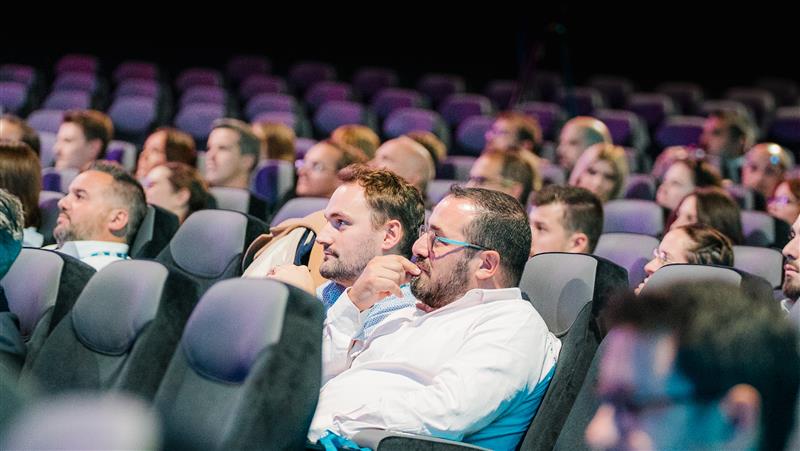 Participants concentrés pendant une conférence dans une salle de cinéma CGR