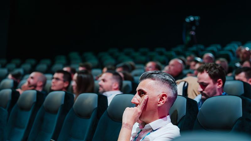 Participant concentré pendant une conférence dans une salle de cinéma CGR