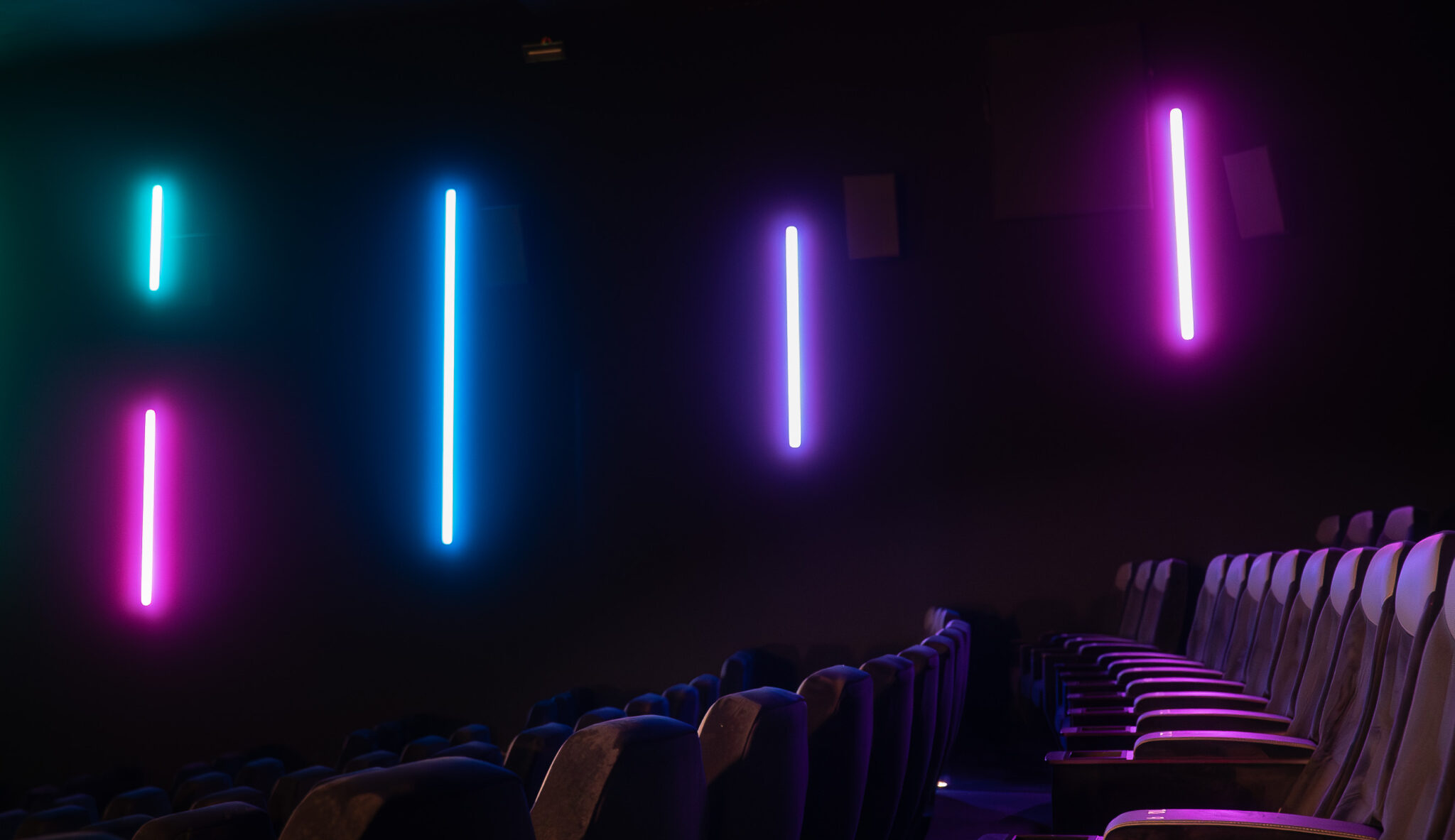 Éclairage LED coloré dans une salle de cinéma CGR avec rangée de fauteuils vides