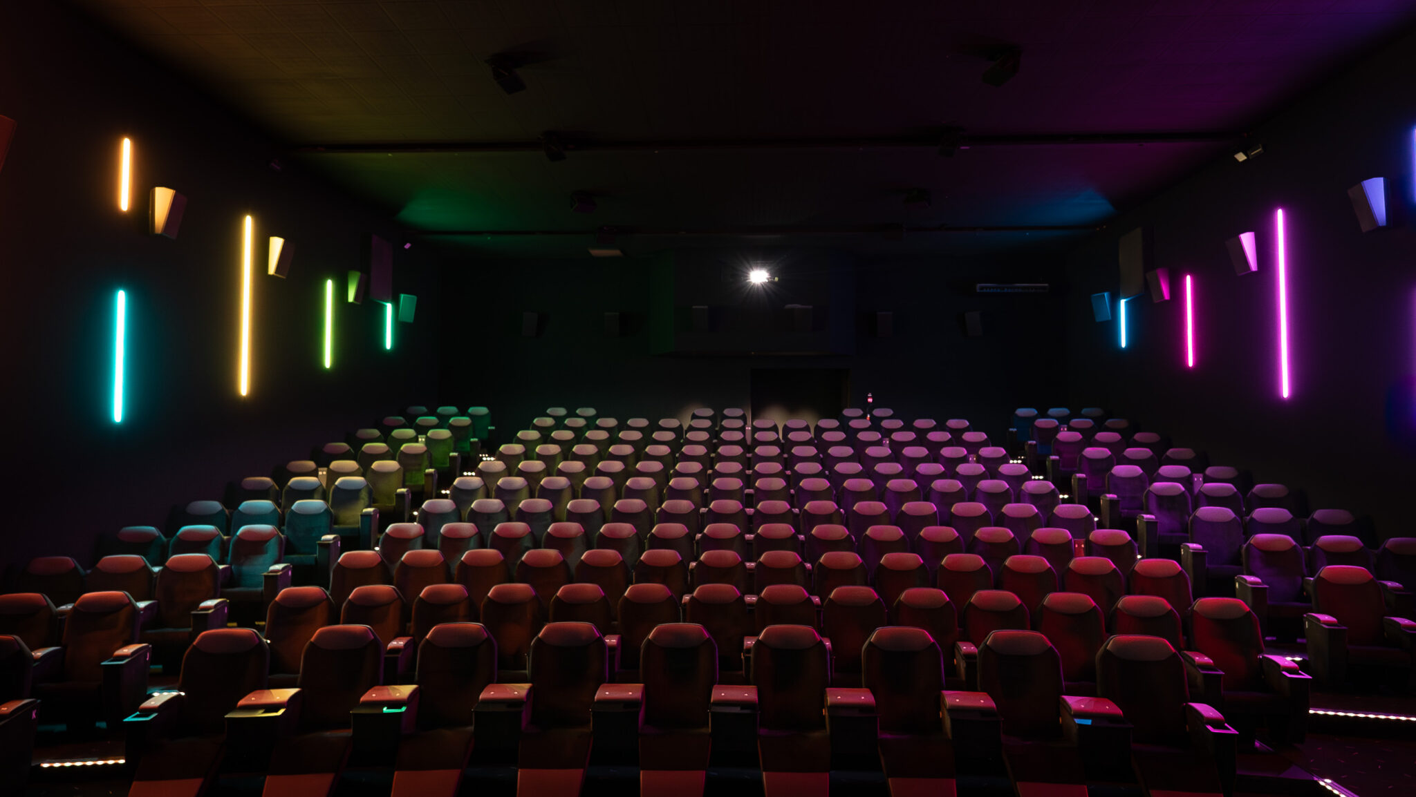 Salle de cinéma CGR vide avec fauteuils premium et éclairage LED multicolore