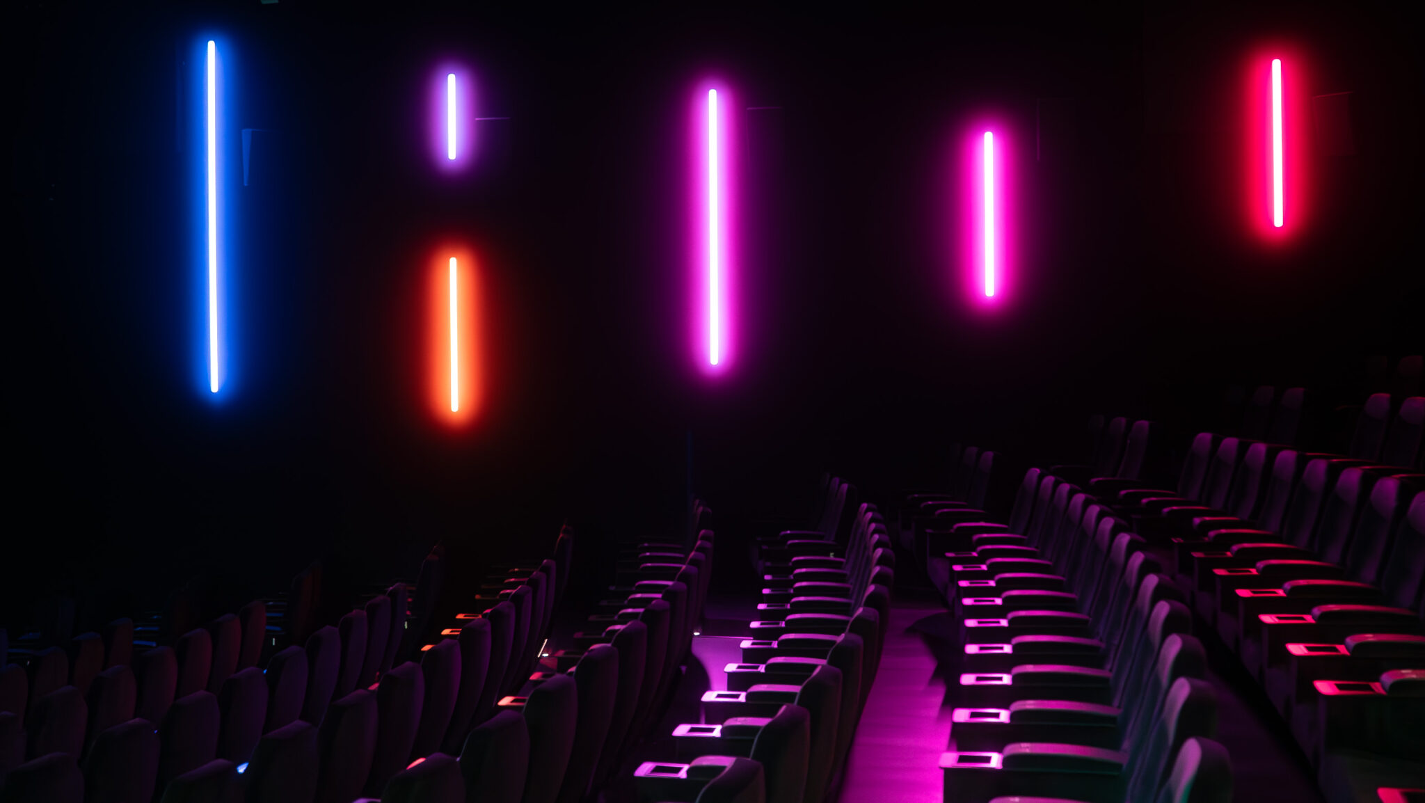 Salle de cinéma CGR vide avec éclairage LED coloré violet, rose et bleu