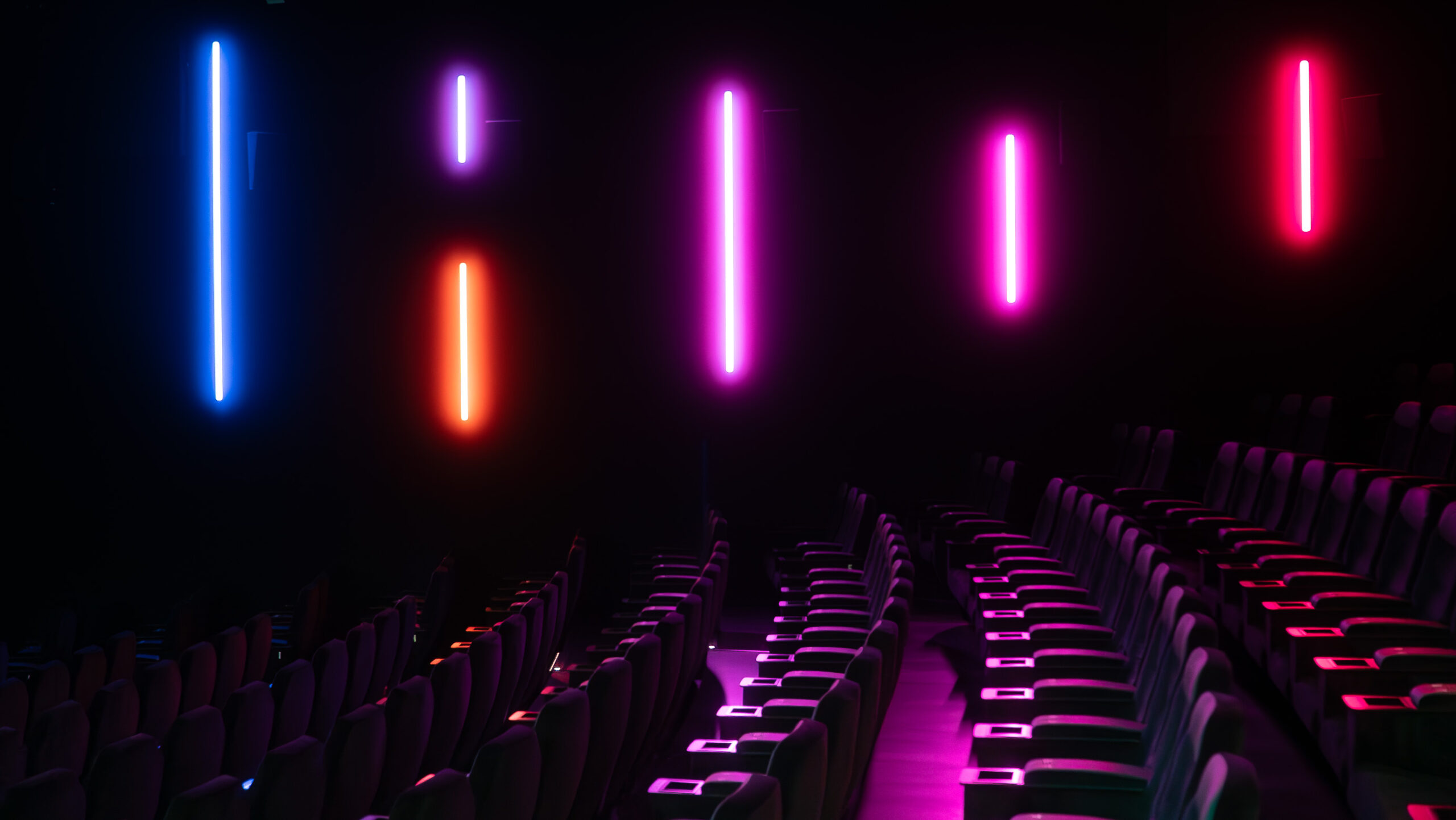 Salle de cinéma CGR vide avec éclairage LED coloré violet, rose et bleu