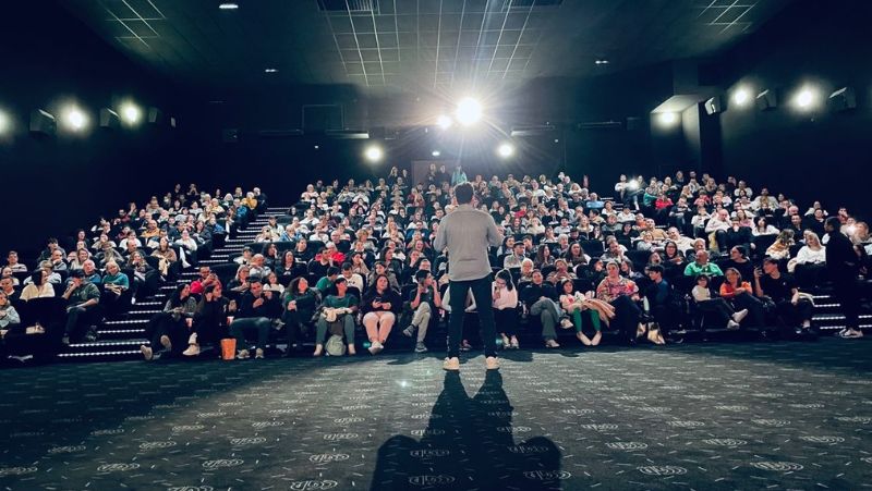 Intervenant sur scène face à un public nombreux dans une salle de cinéma CGR