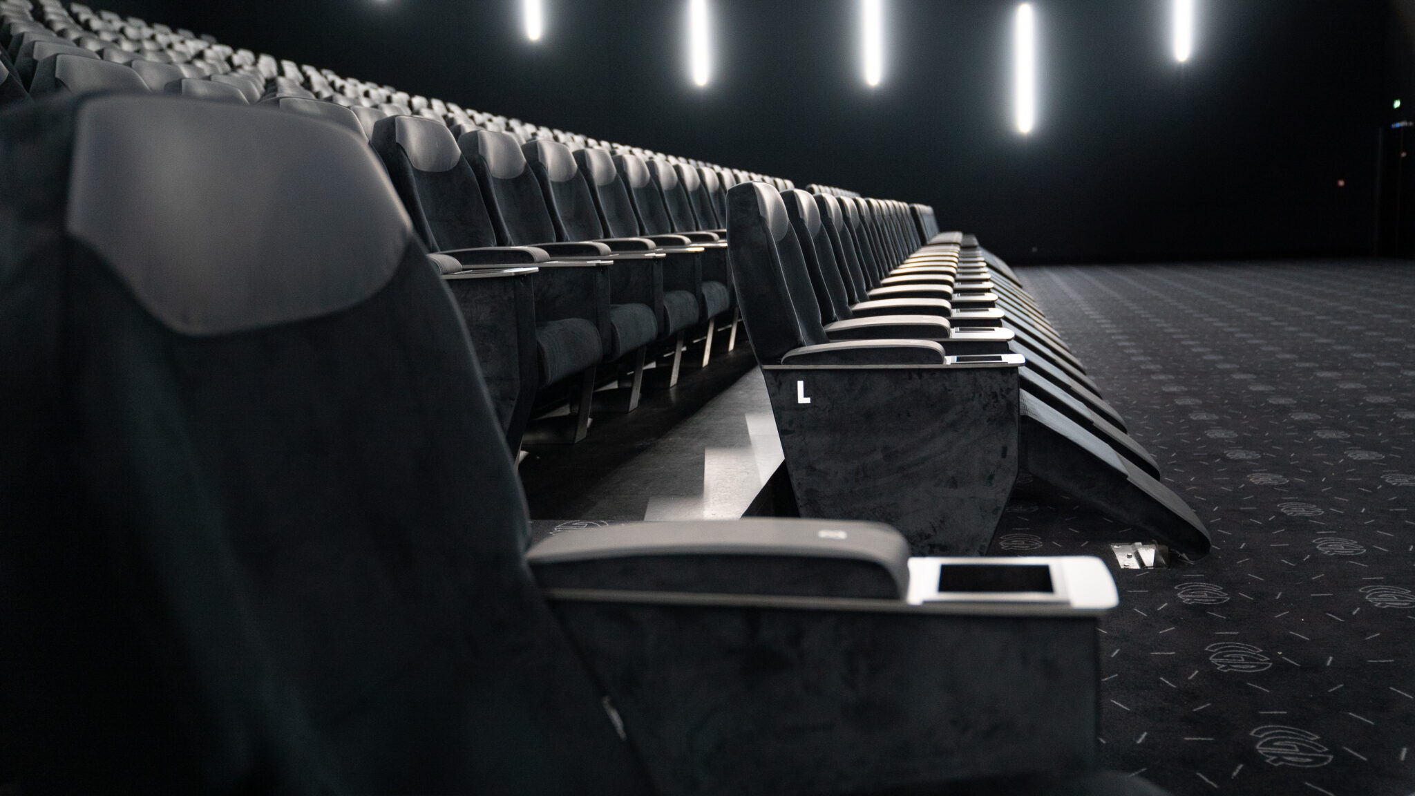 Rangée de fauteuils inclinables premium dans une salle de cinéma CGR vide